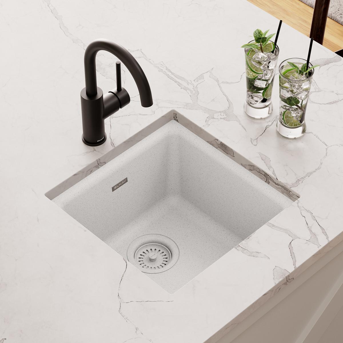 White quartz square bar sink with single bowl and drain, shown installed with black faucet on marble countertop.