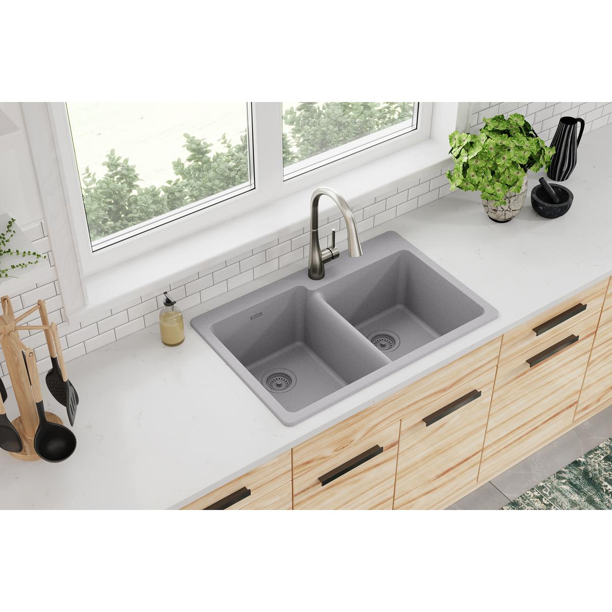 Greystone quartz double bowl drop-in sink with offset design installed in white countertop with pull-down faucet.