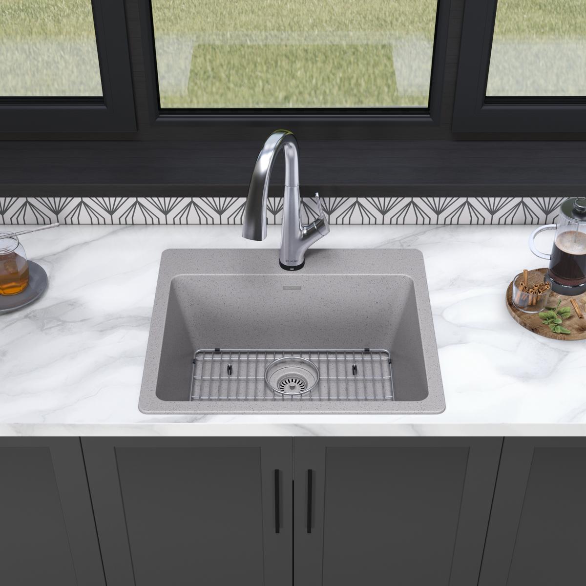 Greystone quartz drop-in sink with single bowl, grid insert, and arched chrome filtered faucet installed in marble countertop