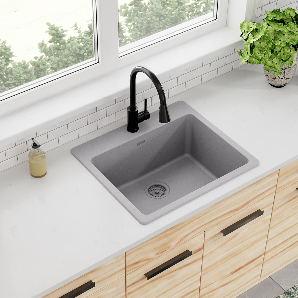 Greystone quartz drop-in sink with single bowl and drain, paired with black pull-down faucet on white countertop.