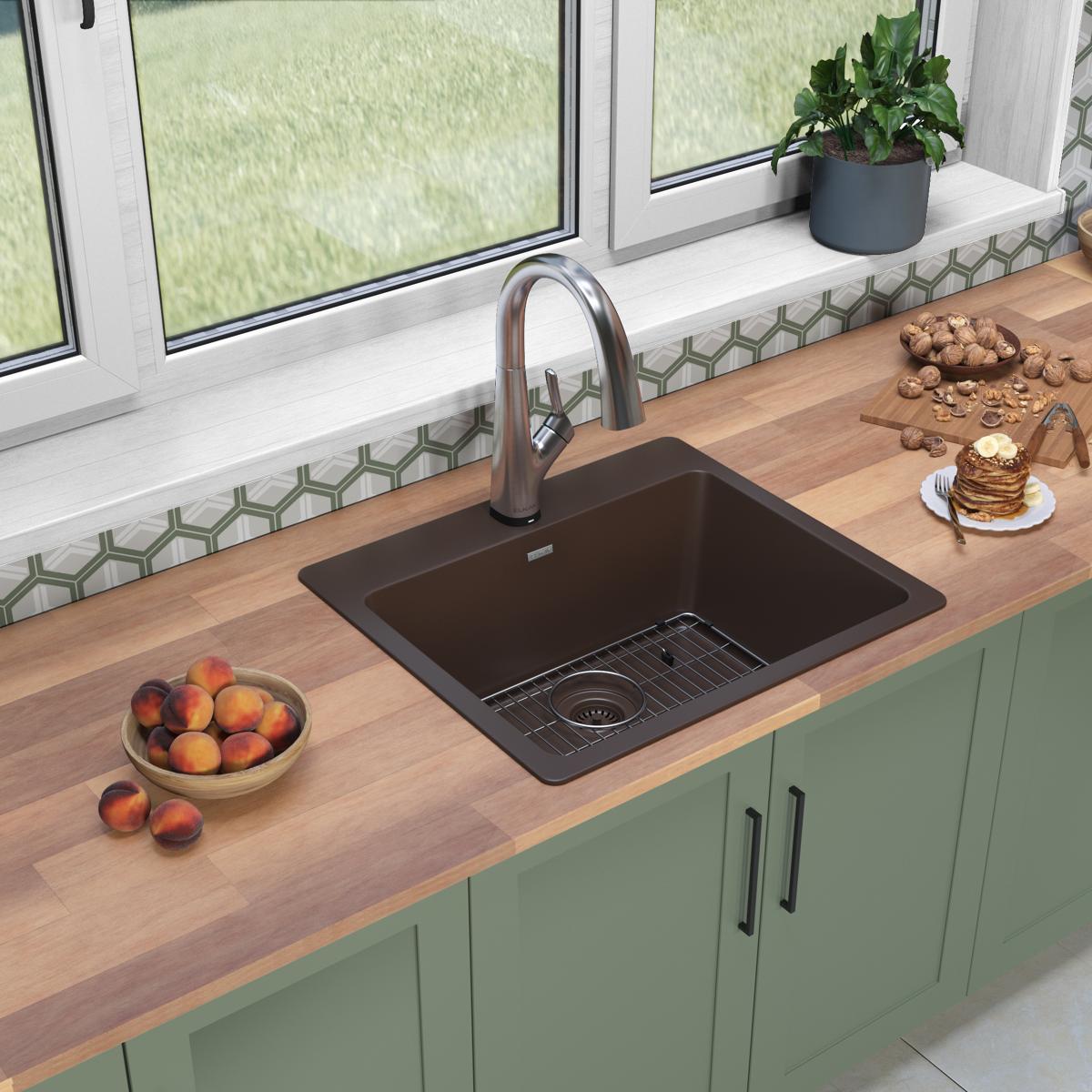 Mocha quartz drop-in sink with single bowl, stainless steel faucet, and grid strainer installed in wooden countertop.