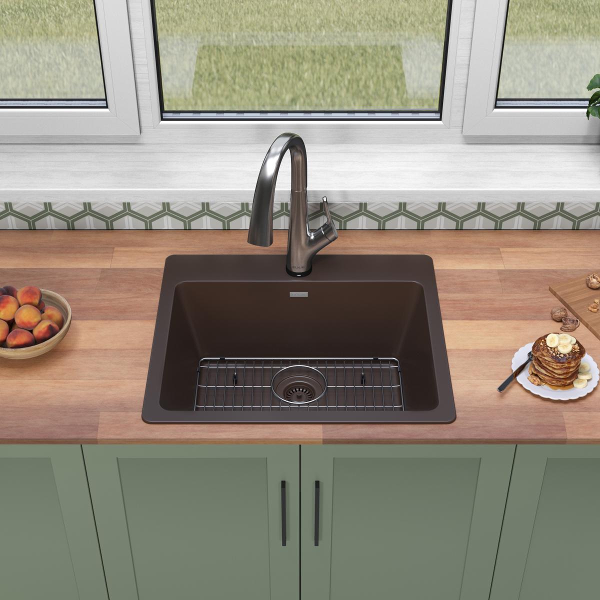 Mocha quartz drop-in sink with single bowl, stainless steel faucet, and grid strainer installed in wood countertop.