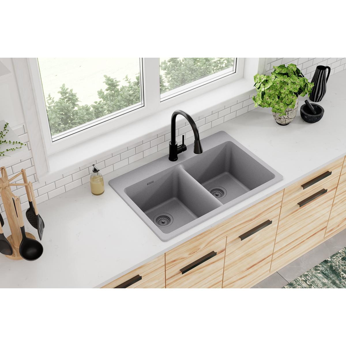 Greystone quartz double bowl drop-in sink with two equal compartments and drain holes installed in white countertop.