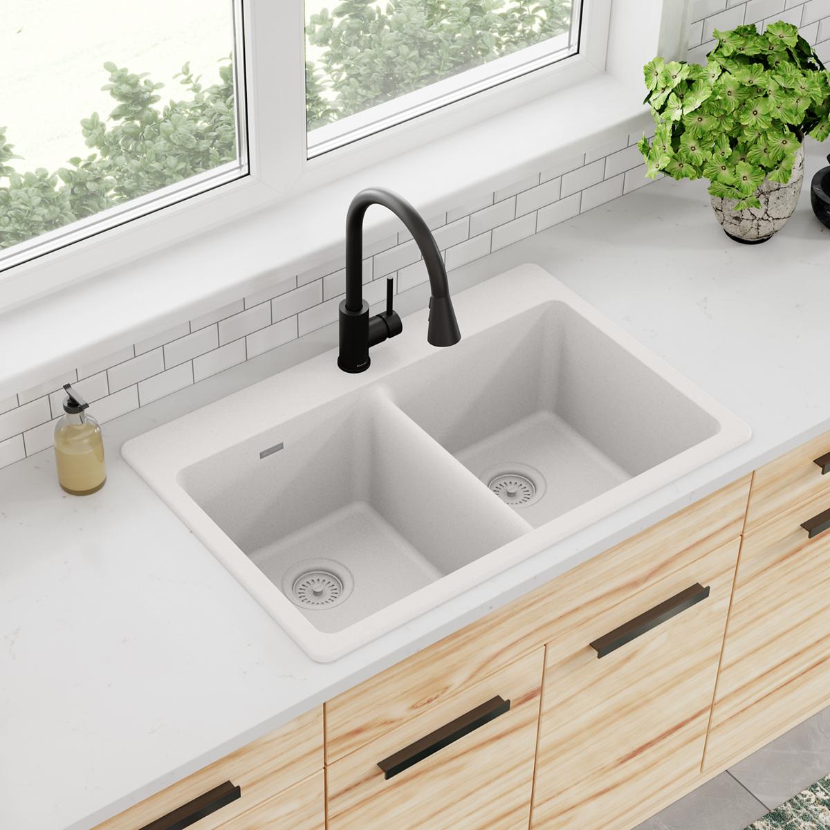 White quartz double bowl drop-in sink with black pull-down faucet installed in kitchen countertop.