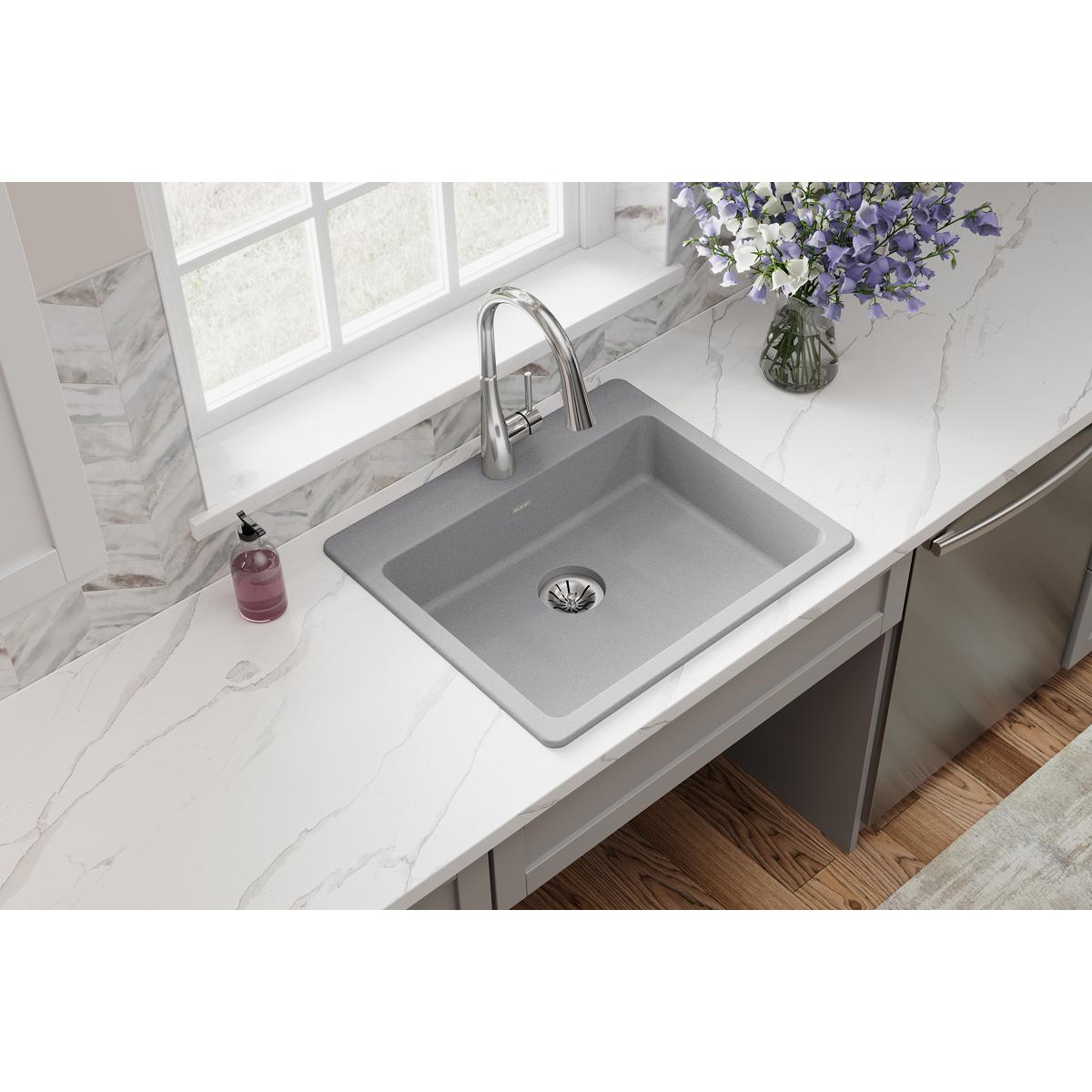 Greystone quartz drop-in sink with single bowl and drain installed in white countertop with faucet.
