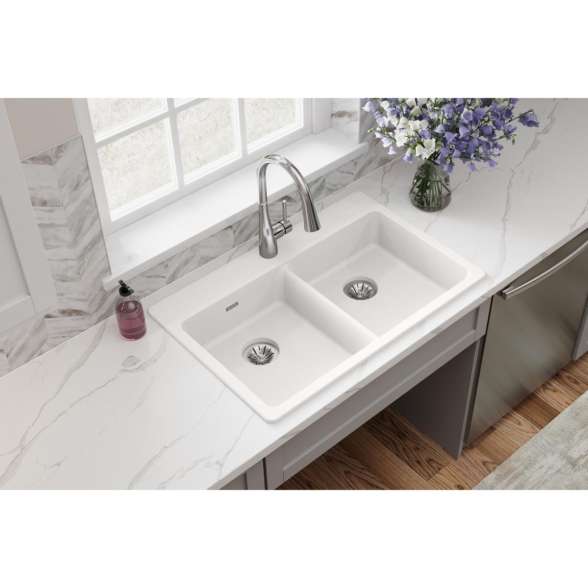 White quartz double bowl drop-in sink with two drains and chrome pull-down faucet installed in marble countertop.