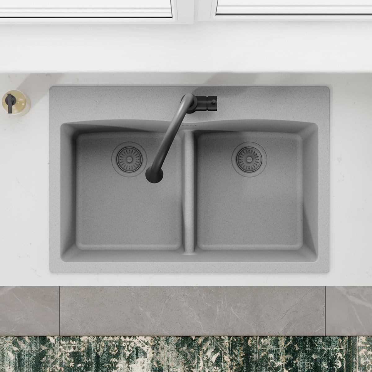 Greystone polymer dual-bowl sink with black drain fitting and removable basket strainer installed in left basin.