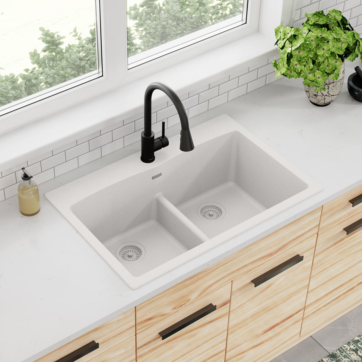 White quartz drop-in sink with two equal bowls, divider, and black pull-down faucet installed in countertop.