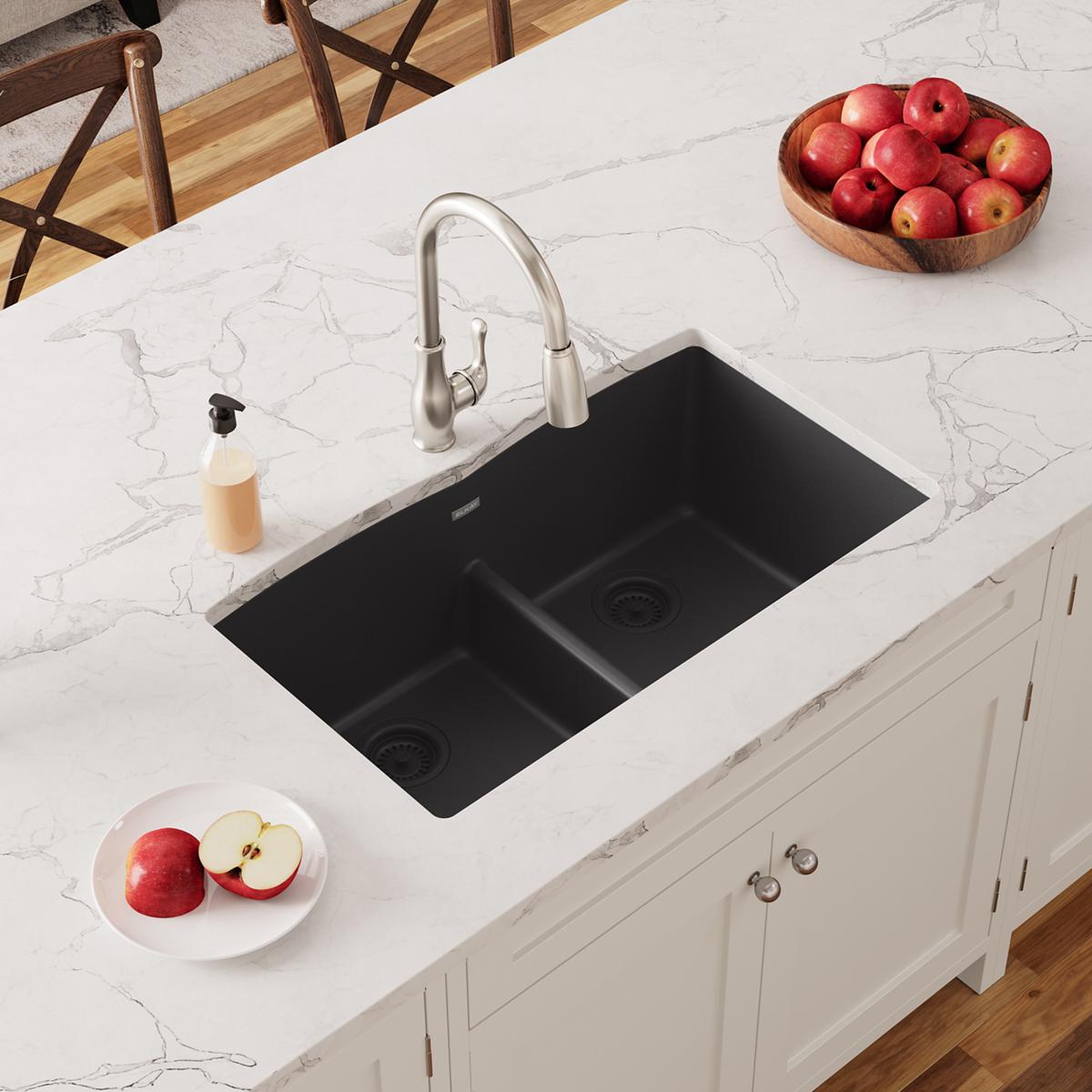 Black quartz undermount double bowl sink with center divider installed in white marble countertop.