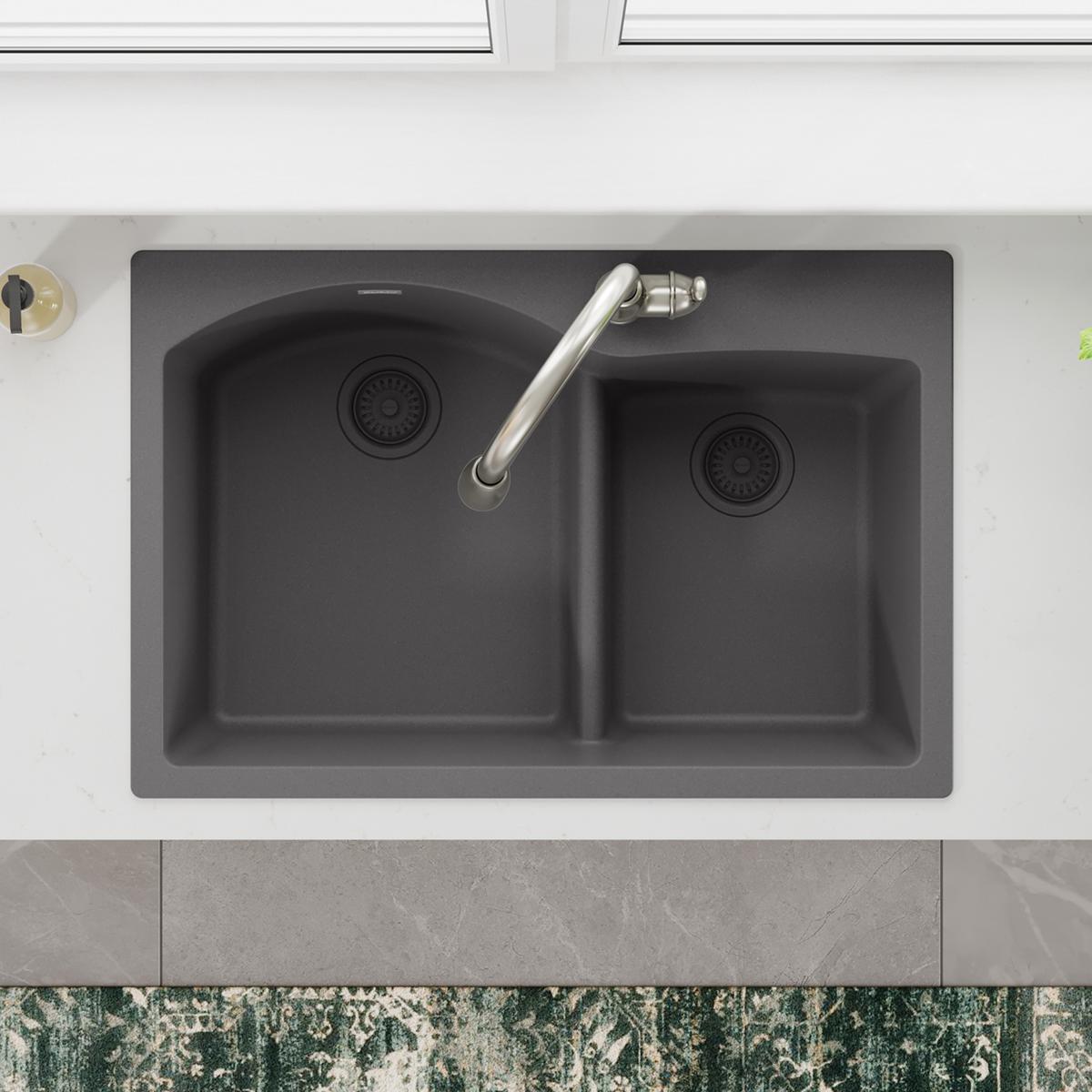 Dusk gray polymer double-bowl sink with disposer flange, removable basket strainer, and rubber stopper in left bowl.