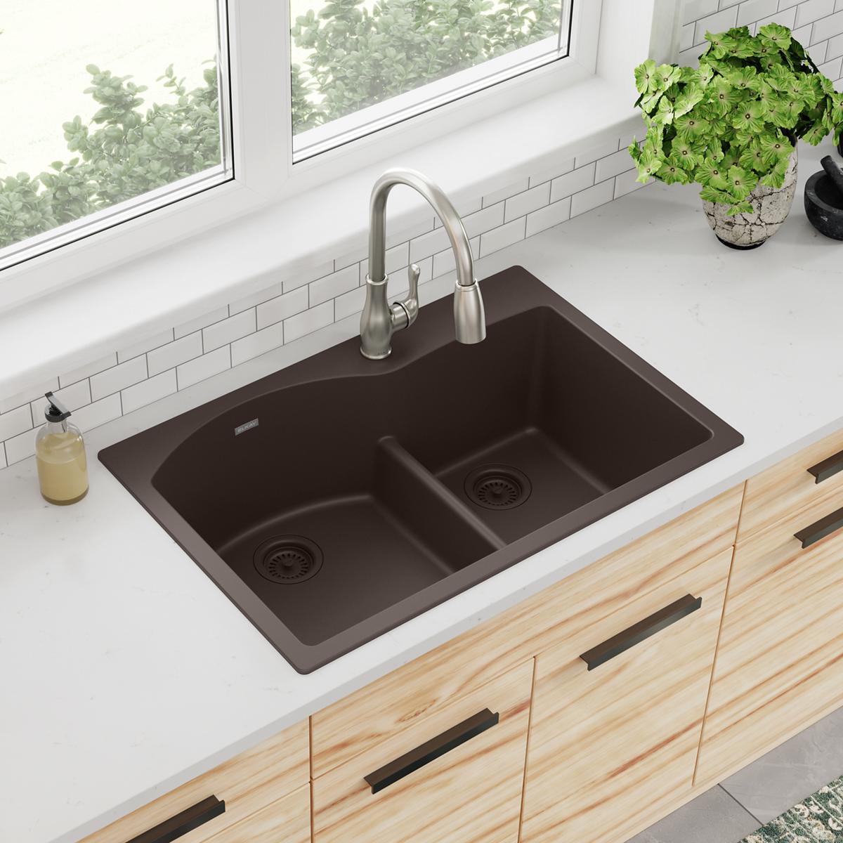 Mocha quartz drop-in sink with two offset bowls, divider, and stainless steel faucet installed in white countertop.
