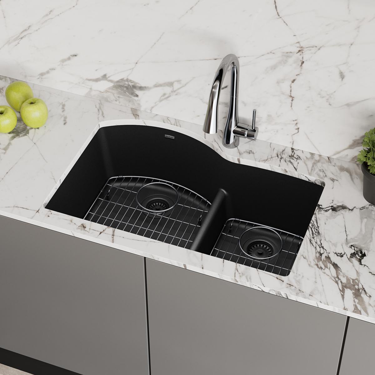 Black quartz double bowl undermount sink with unequal 60/40 bowl sizes, chrome faucet, and grid strainers installed in marble