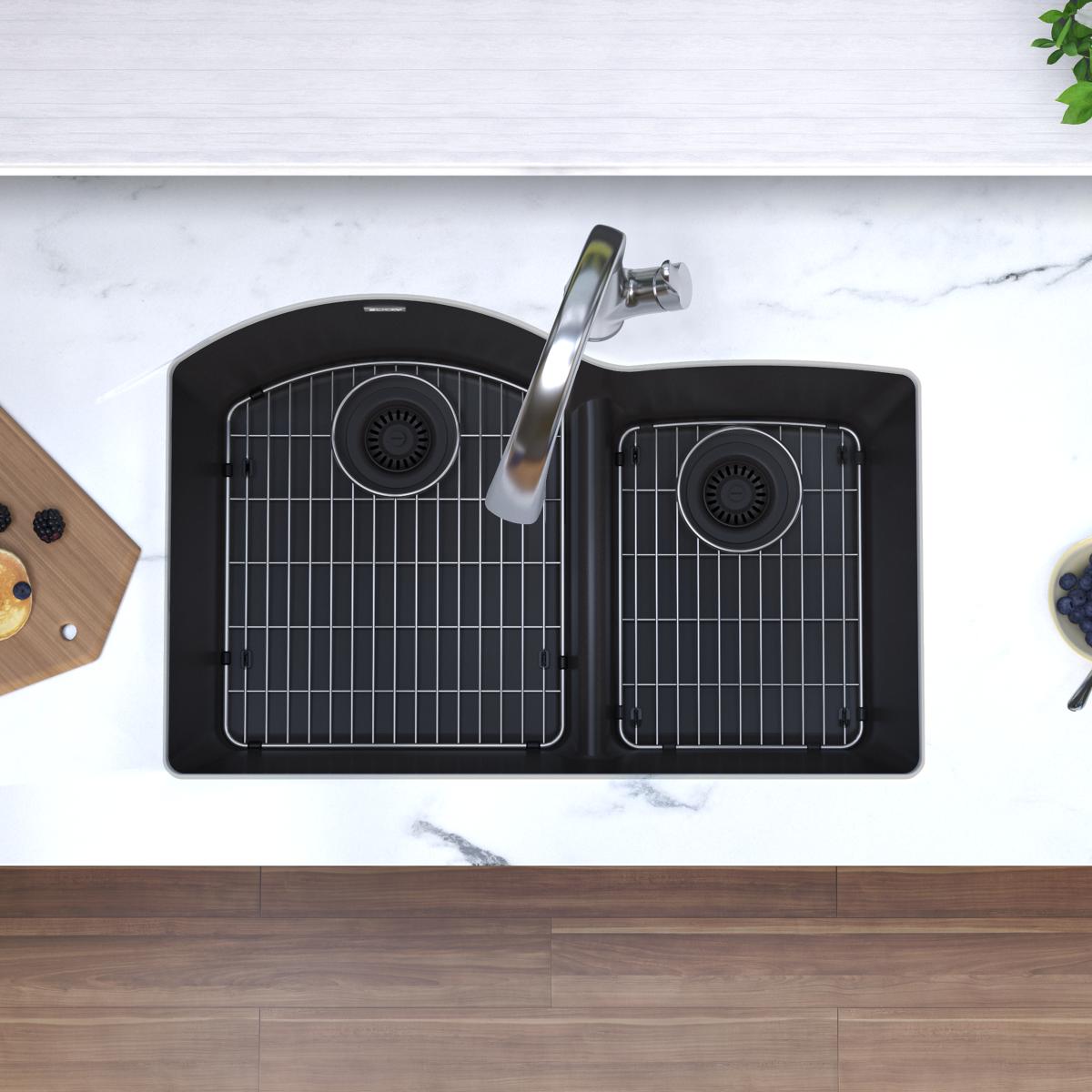 Black quartz double bowl undermount sink with chrome filtered faucet installed in marble countertop, viewed from above.