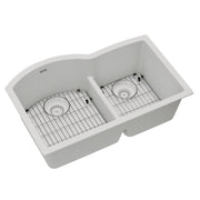 White quartz double bowl undermount sink with offset basins, wire grids, and drain strainers.