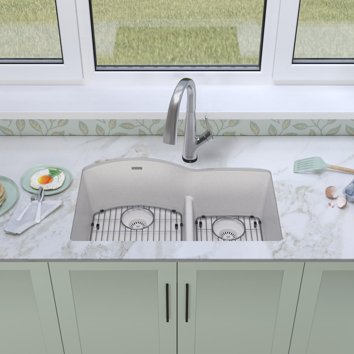 White quartz double bowl undermount sink with offset 60/40 configuration, dual drain grids, and arched chrome faucet installe