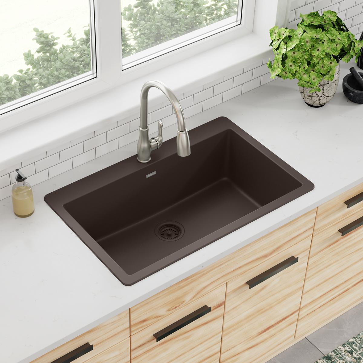 Mocha quartz single bowl drop-in kitchen sink with brushed nickel faucet installed in white countertop.