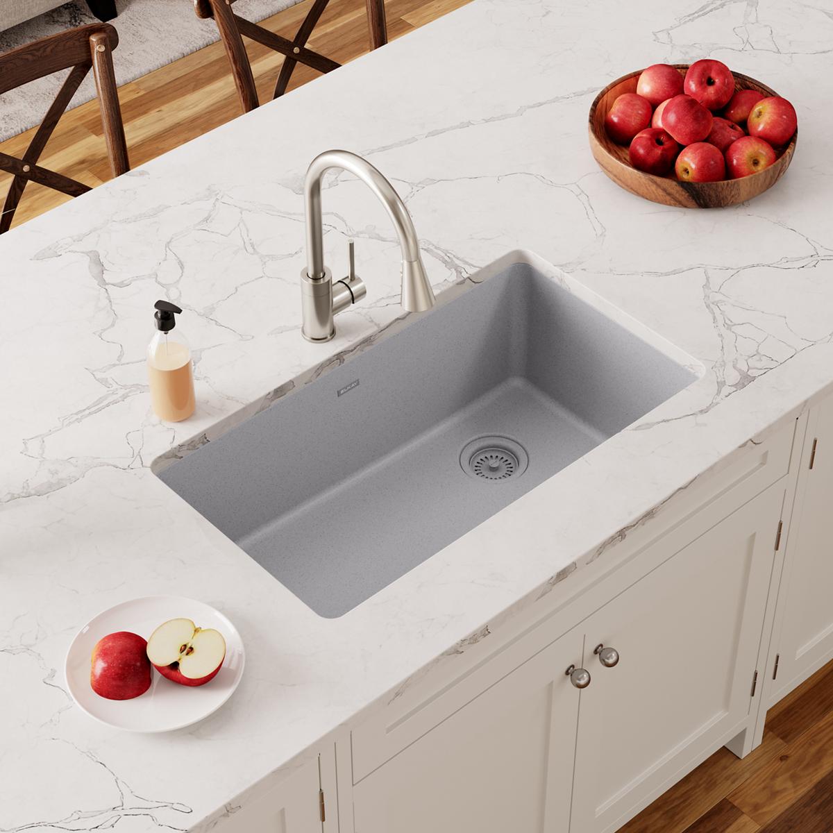 Greystone quartz undermount sink with single rectangular basin and drain, installed in white countertop with stainless steel 
