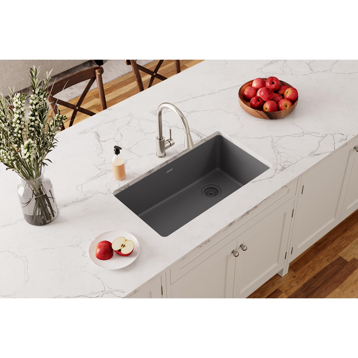Dusk gray single-bowl undermount sink installed in white marble countertop with stainless steel faucet.