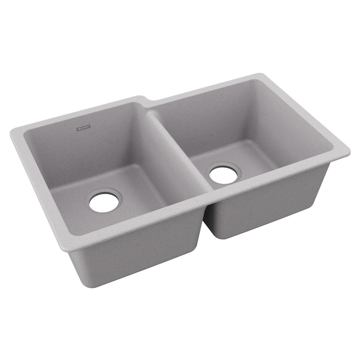 Greystone quartz double bowl undermount sink with offset bowls and drain holes visible.