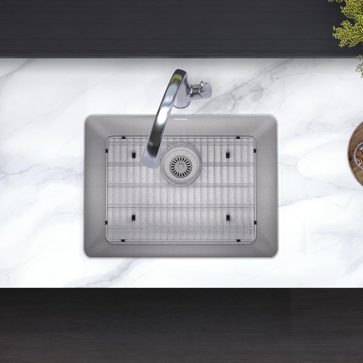 Greystone quartz single bowl undermount sink with stainless steel faucet and grid strainer, installed in marble countertop.