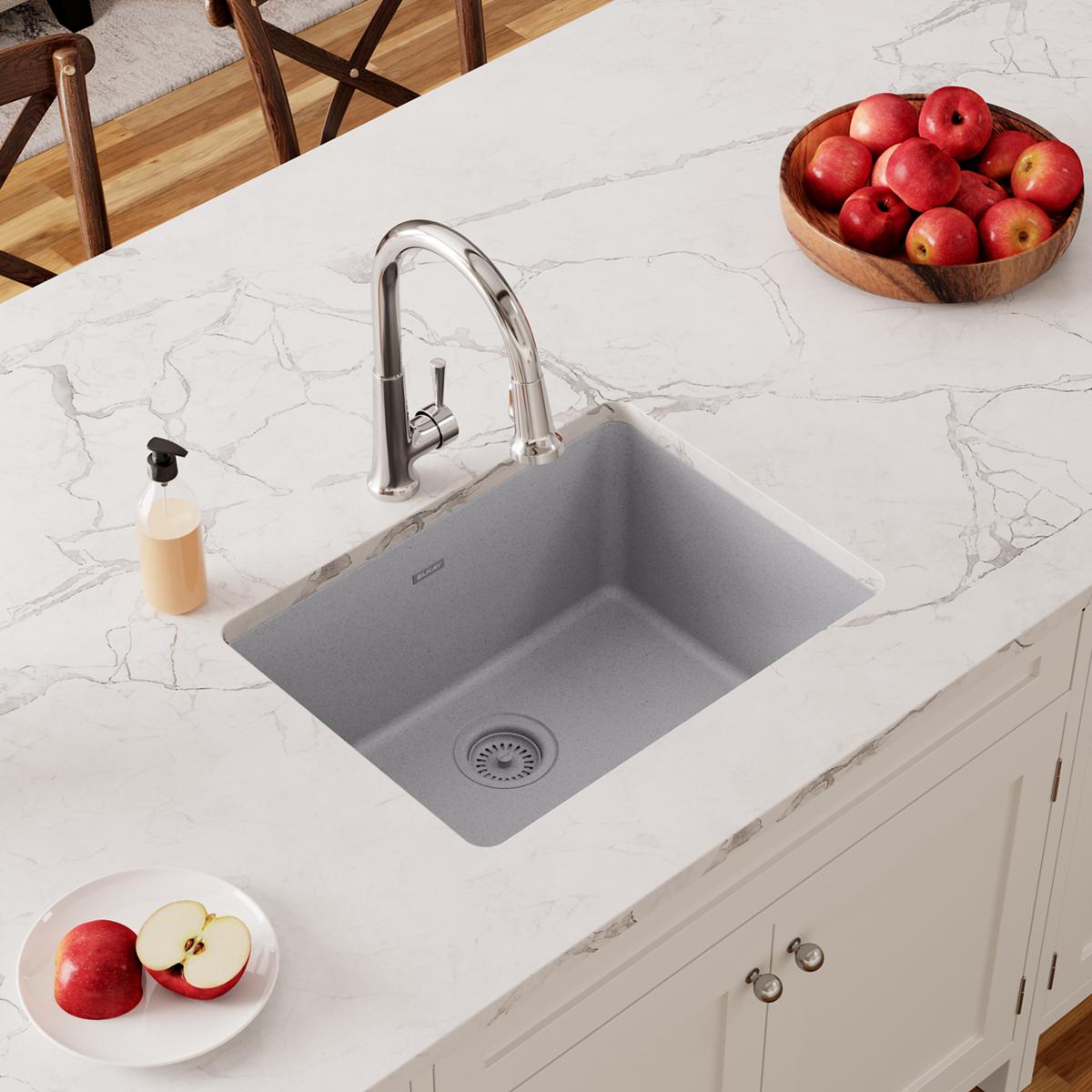 Greystone quartz undermount sink installed in white marble countertop with chrome faucet and drain strainer visible.