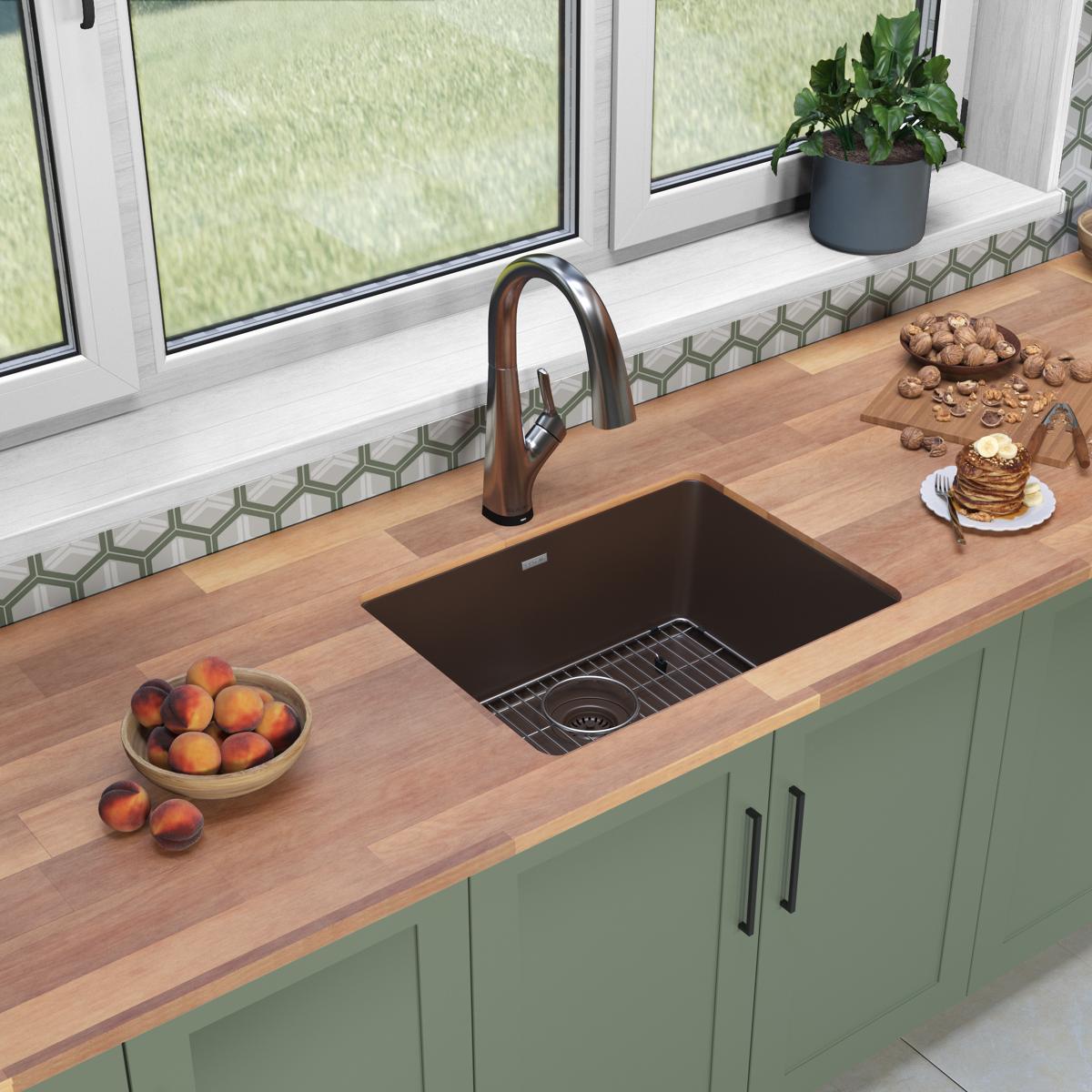 Mocha quartz single bowl undermount sink with filtered faucet installed in wooden countertop above green cabinetry.