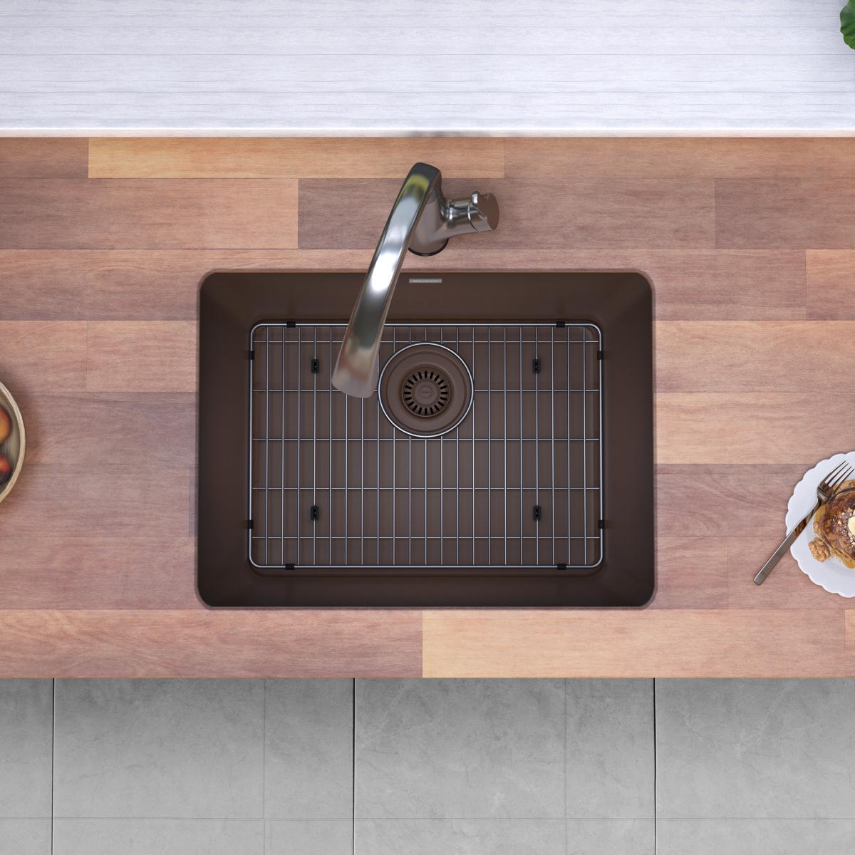 Mocha quartz undermount kitchen sink with single bowl, grid insert, and curved filtered faucet installed in wooden countertop