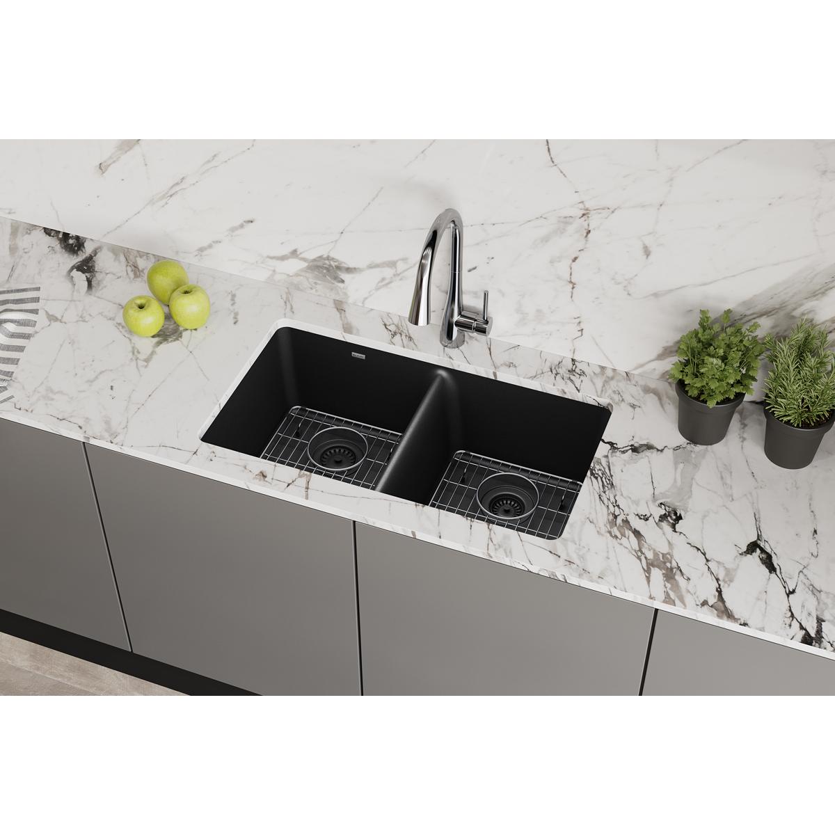 Black quartz double bowl undermount sink with chrome faucet installed in marble countertop.