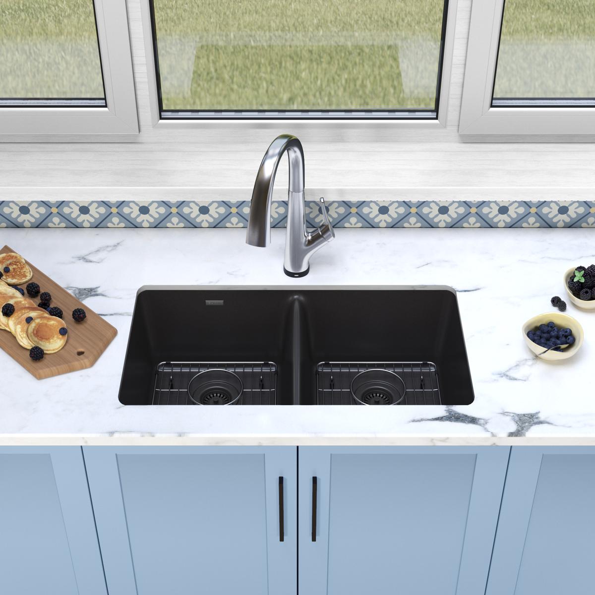 Black quartz double bowl undermount sink with stainless steel filtered faucet installed in marble countertop.