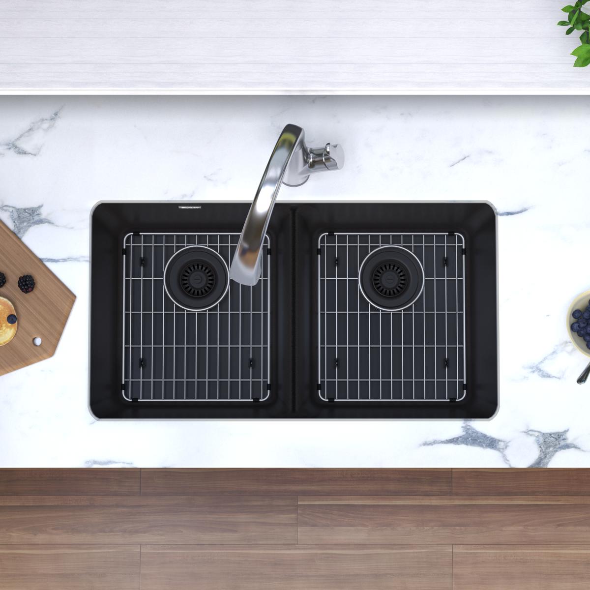Black quartz double bowl undermount sink with two equal compartments, stainless steel faucet, and grid inserts.