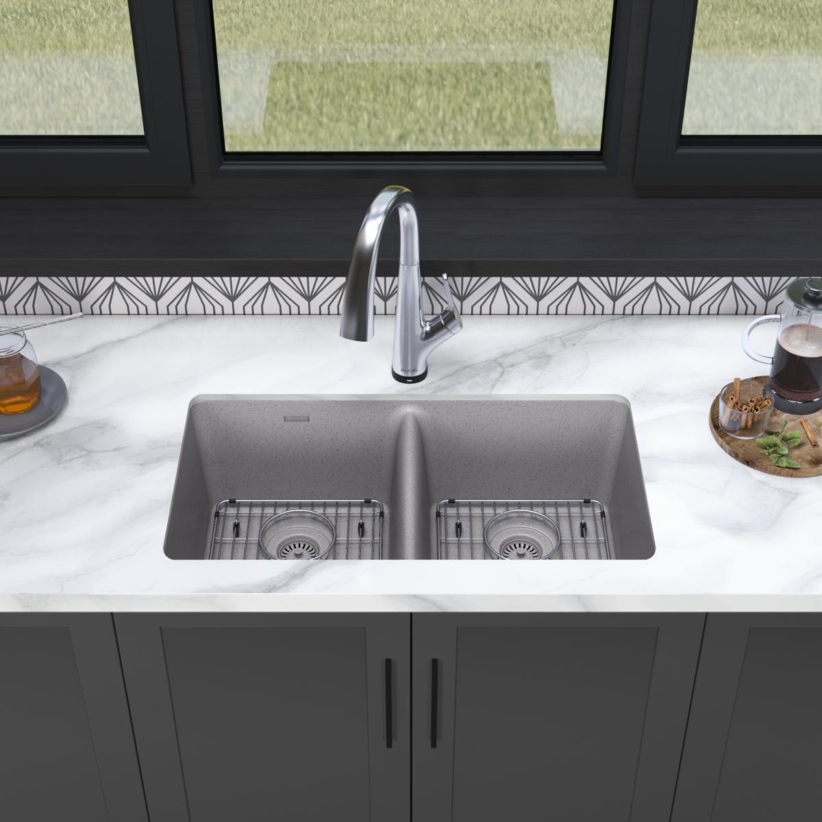 Greystone quartz double bowl undermount sink with chrome filtered faucet installed in white marble countertop.
