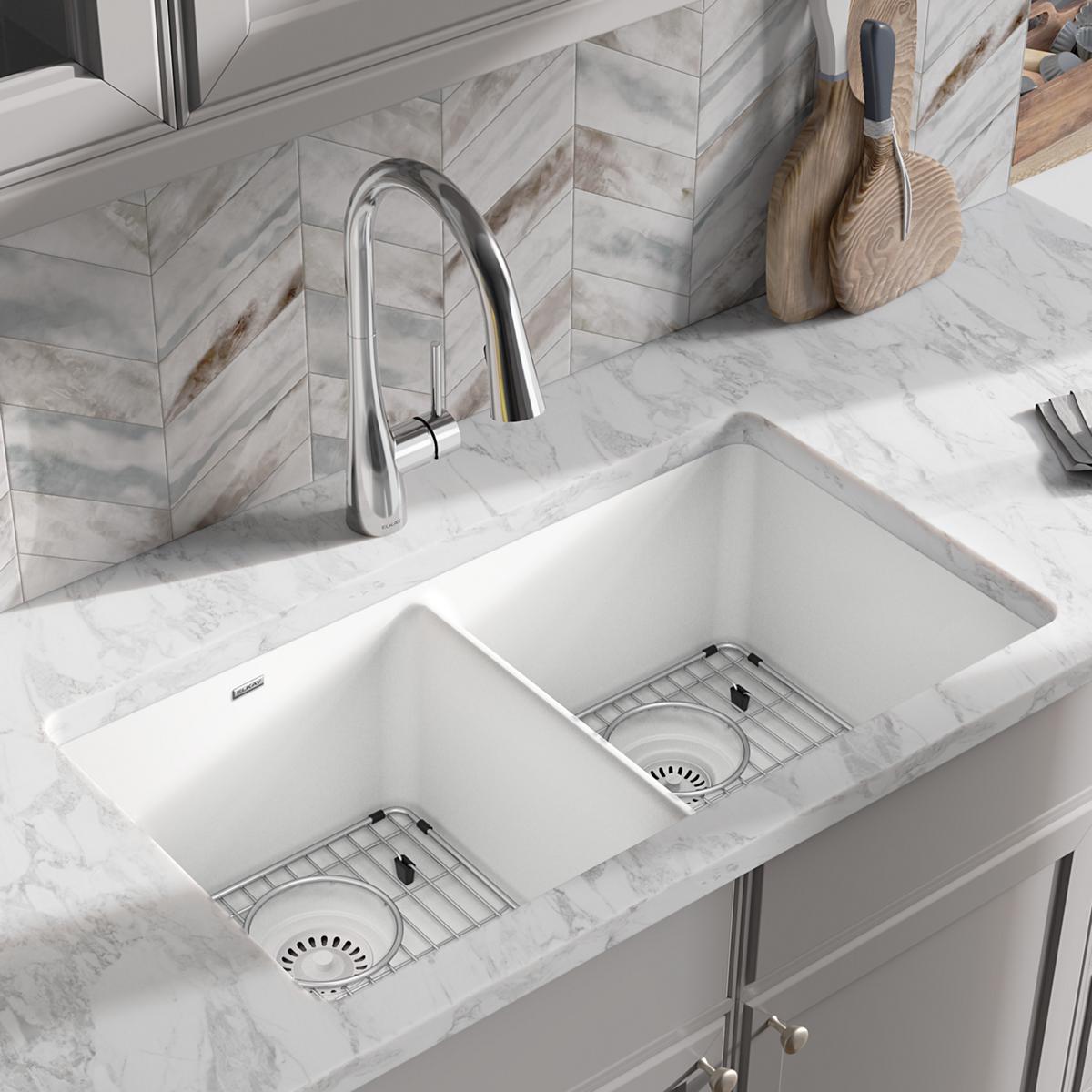 White quartz equal double bowl undermount sink with two rectangular basins and stainless steel grid inserts.