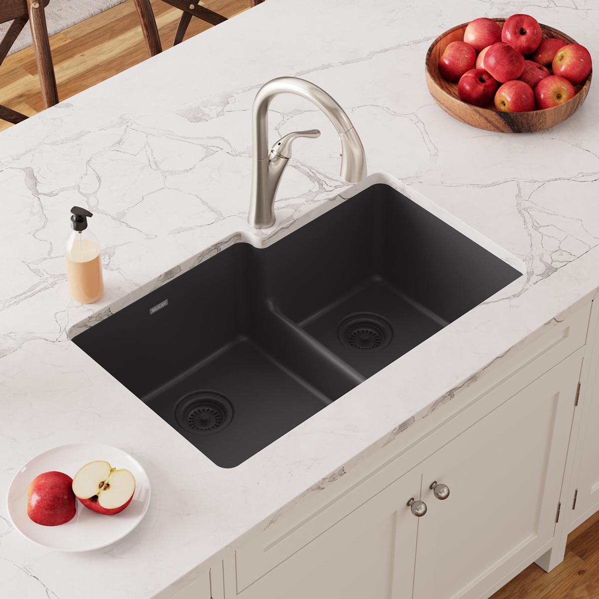 Black quartz double bowl undermount sink with divider and stainless steel faucet installed in white countertop.