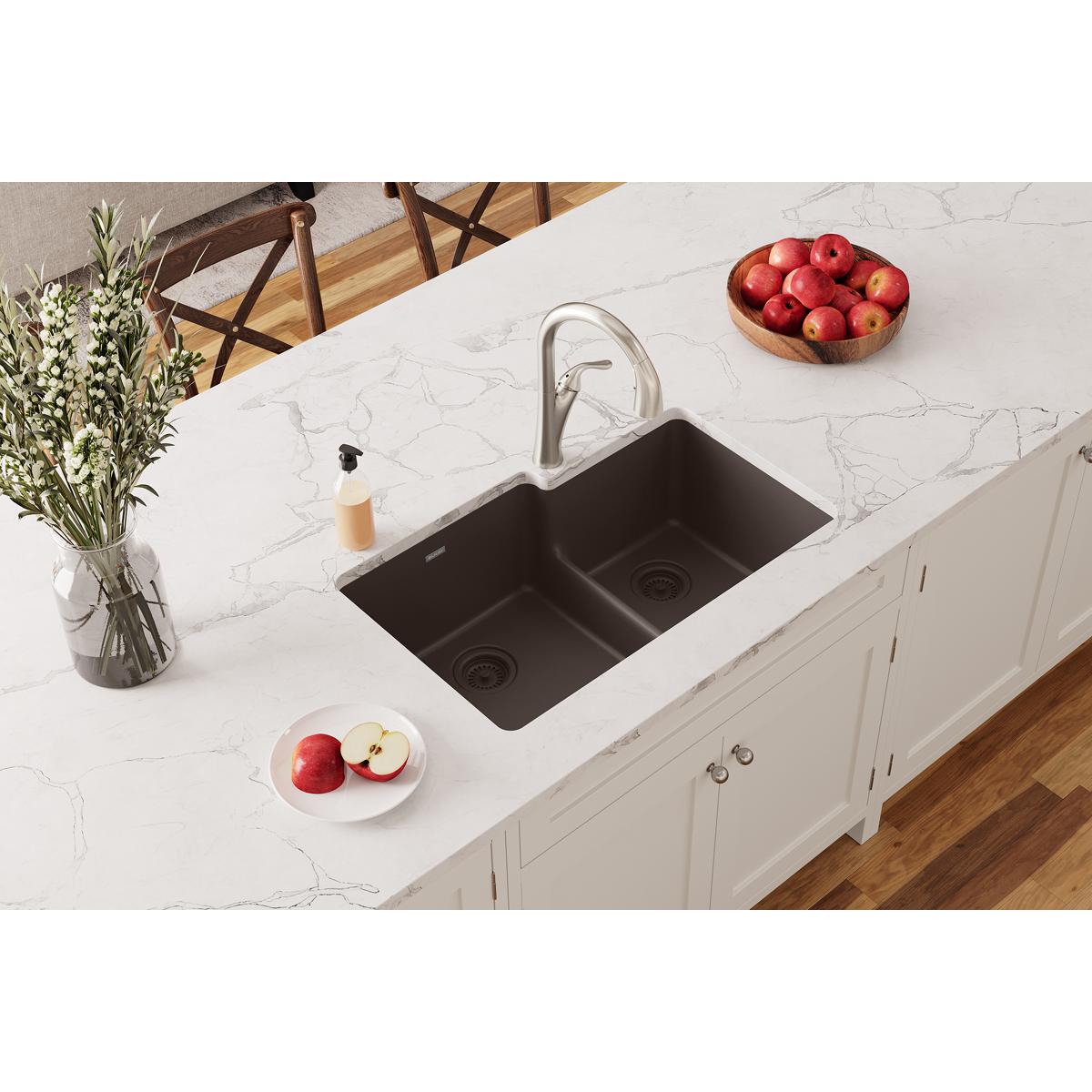 Mocha quartz double bowl undermount sink with divider installed in white marble countertop, chrome faucet visible.