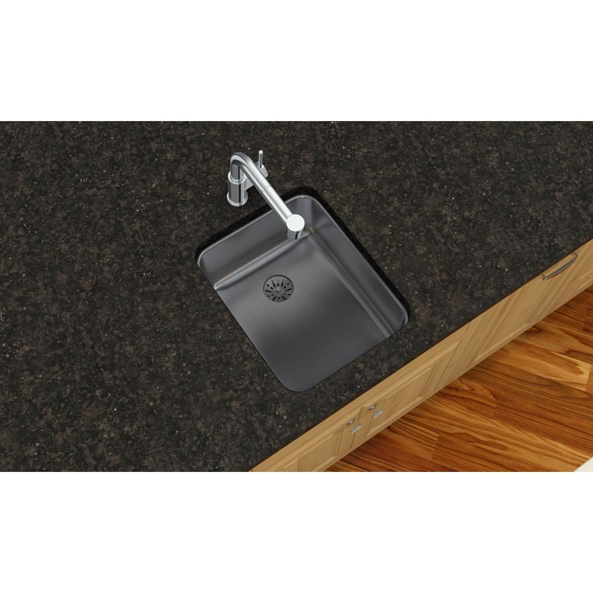 Stainless steel single bowl undermount sink installed in dark granite countertop with chrome faucet.