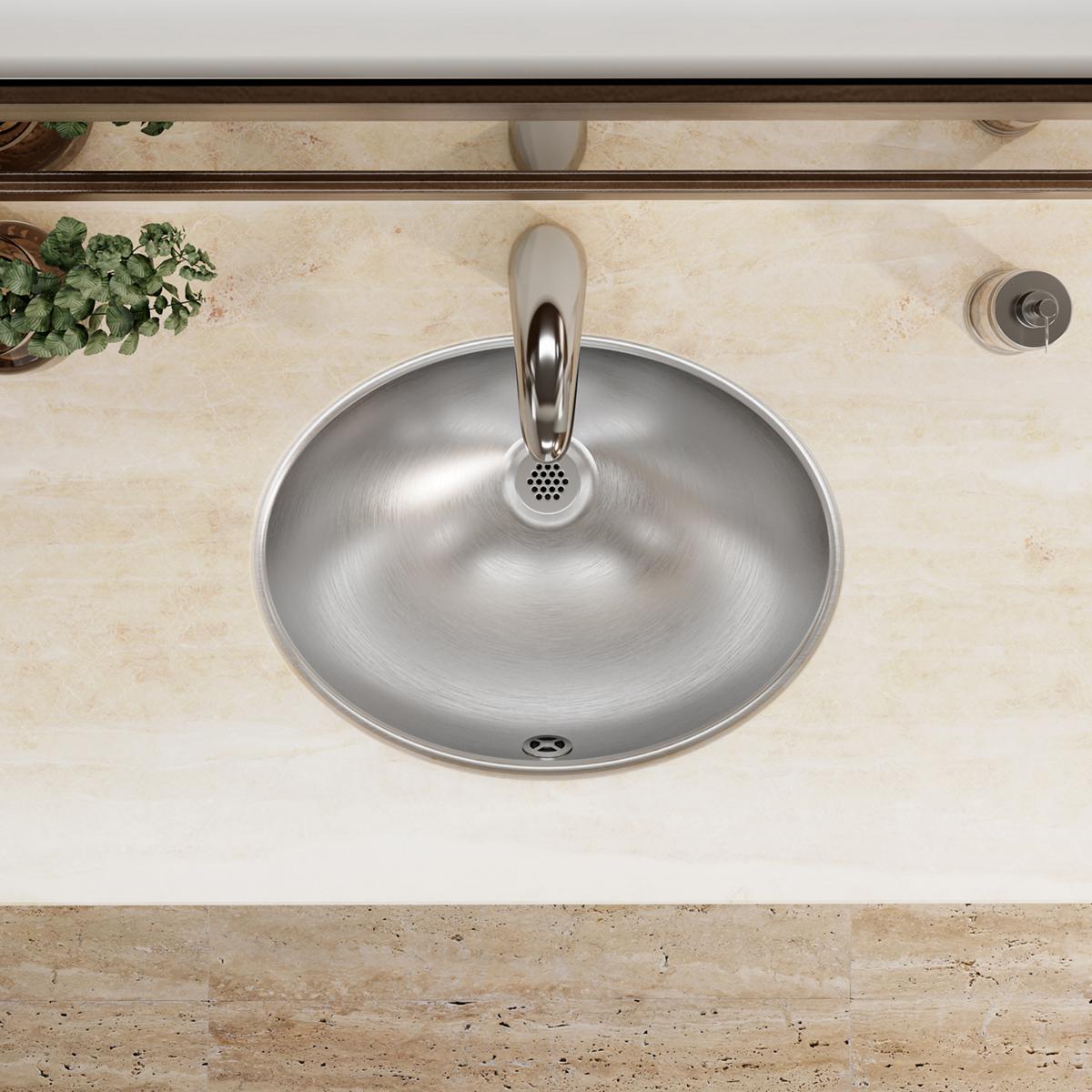 Stainless steel round undermount sink installed in beige marble countertop with single faucet hole and overflow drain.
