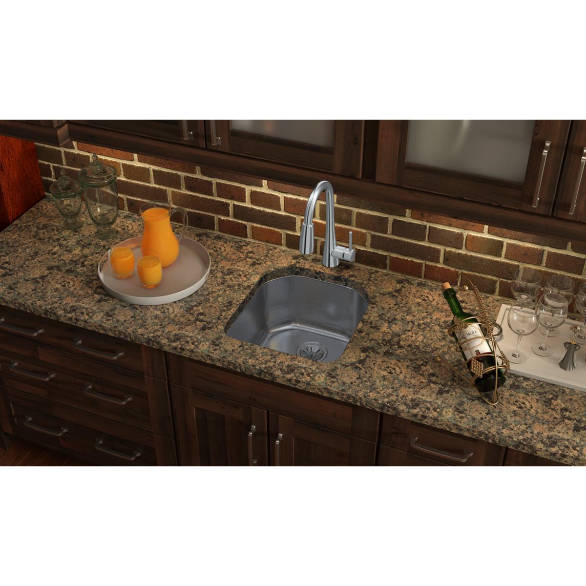 Stainless steel single bowl undermount sink installed in granite countertop with chrome faucet.