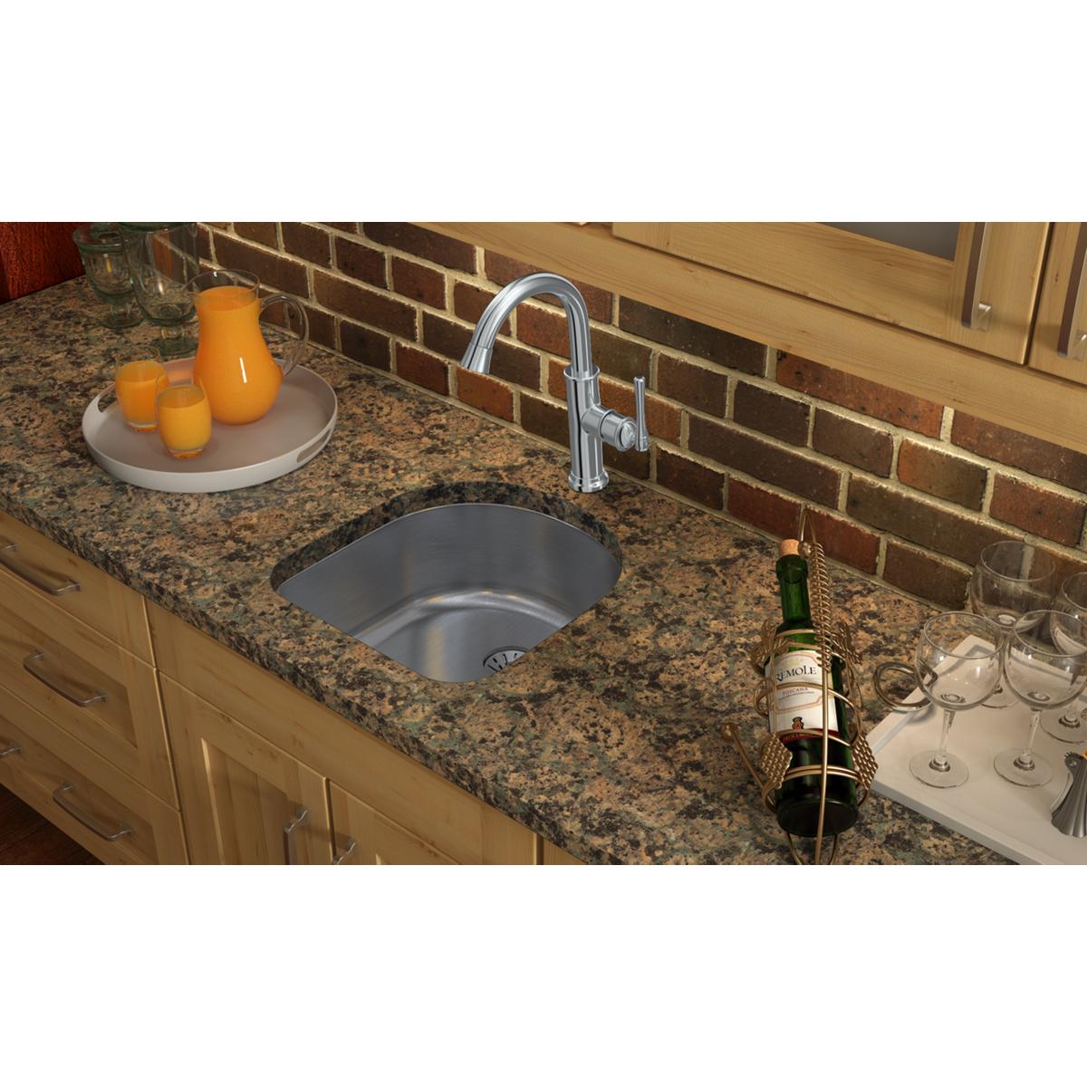 Stainless steel single bowl undermount sink installed in granite countertop with chrome faucet.