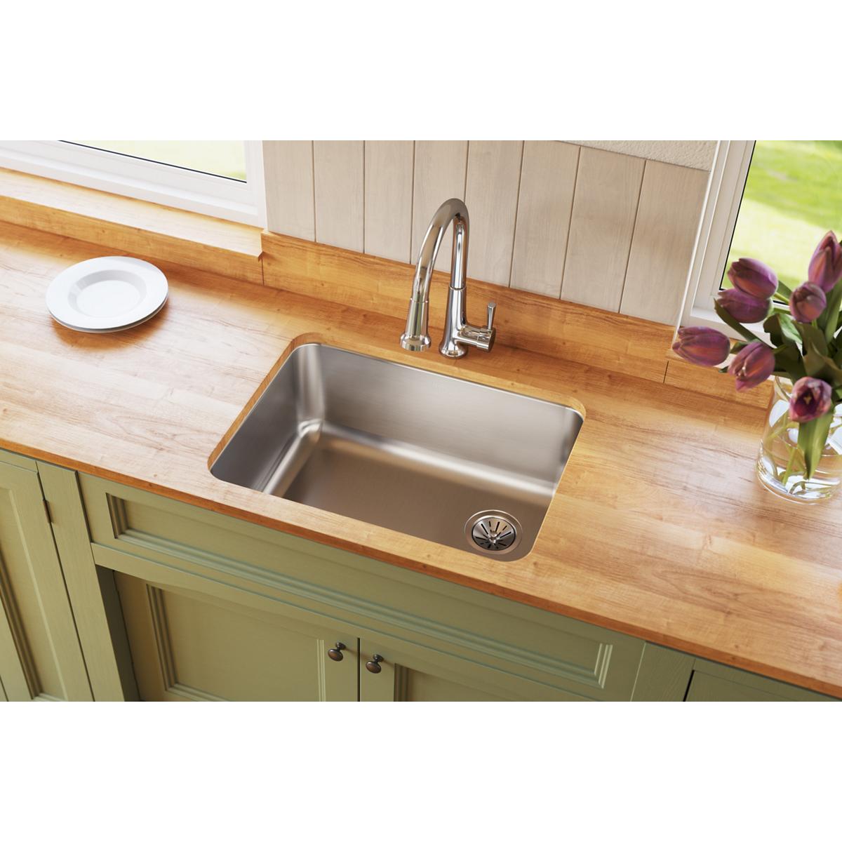 Stainless steel single bowl undermount sink installed in wooden countertop with chrome faucet and right-side drain.