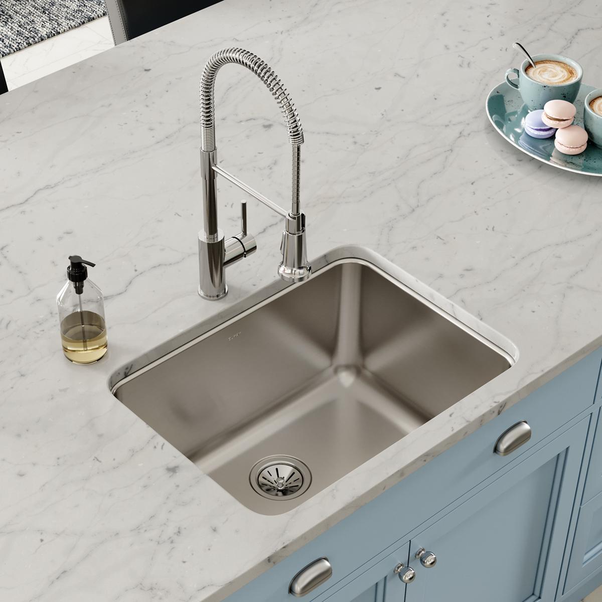 Stainless steel single bowl undermount sink installed in marble countertop with chrome pull-down faucet.