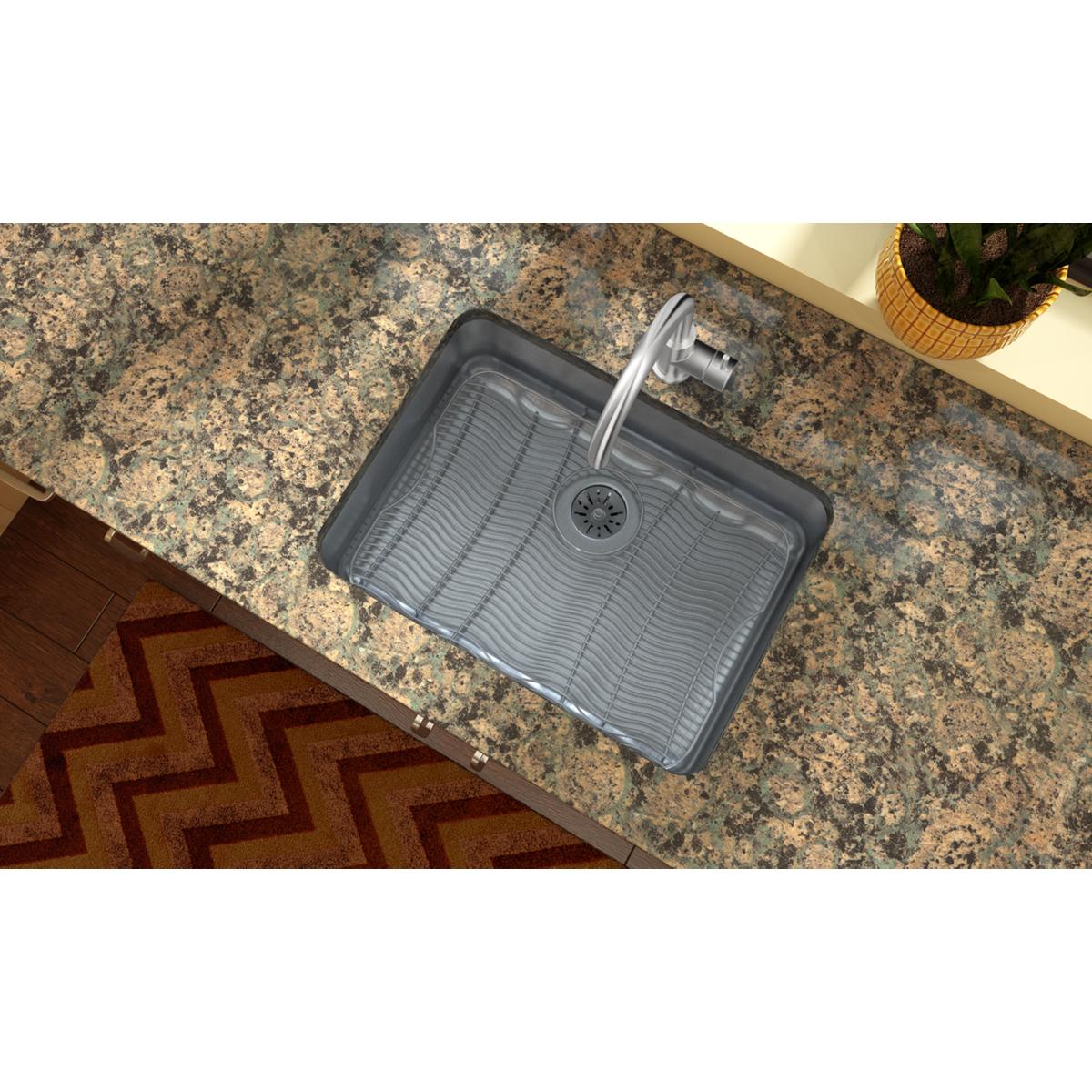 Stainless steel single bowl undermount sink with ribbed basin and drain hole, installed in speckled granite countertop.