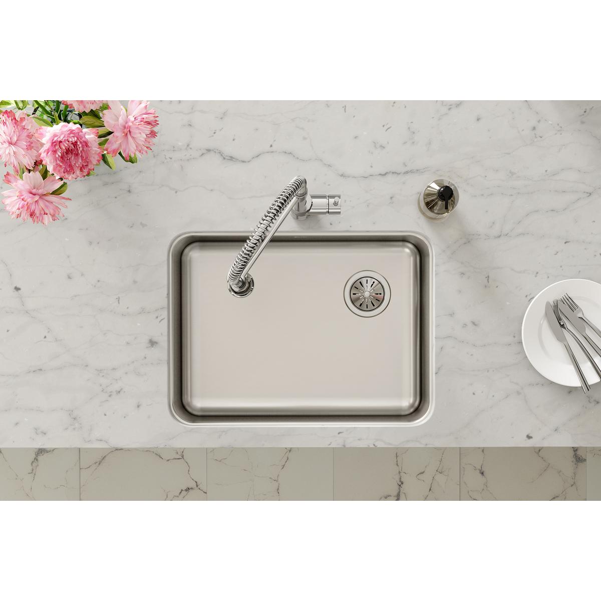 Stainless steel single bowl undermount sink with right drain installed in marble countertop, shown with faucet and drain stra
