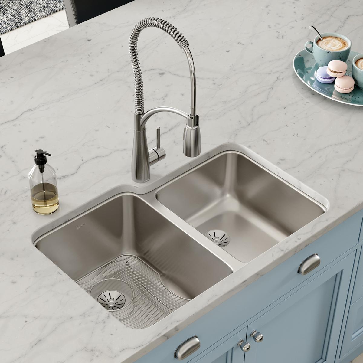 Stainless steel double bowl undermount sink installed in marble countertop with pull-down faucet and drain baskets.
