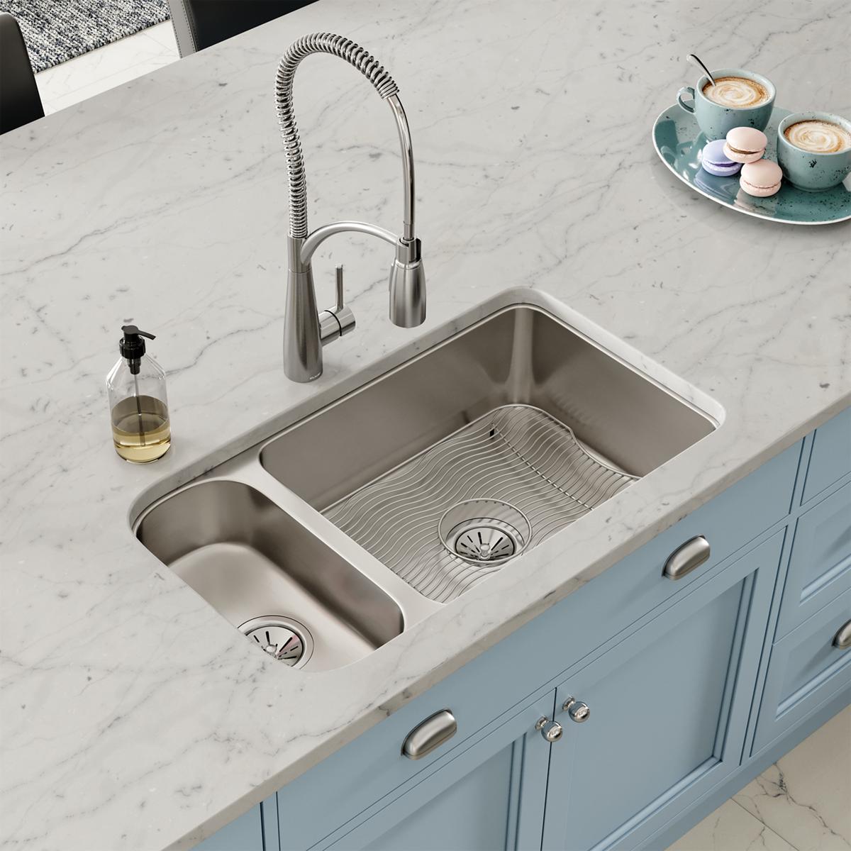 Stainless steel double bowl undermount sink with one larger and one smaller basin, featuring drain strainers and installed in