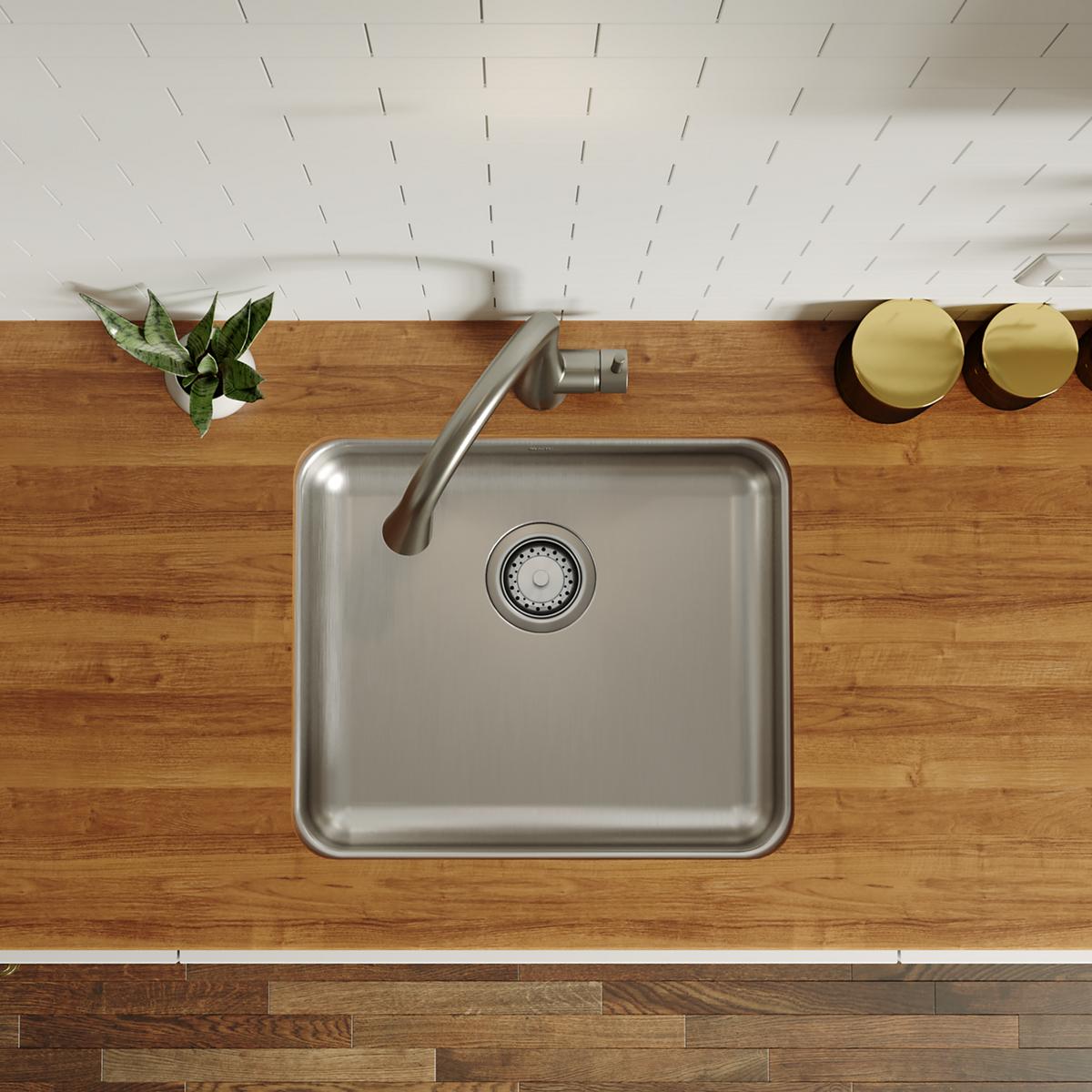 Stainless steel single bowl undermount sink with drain strainer installed in wooden countertop.