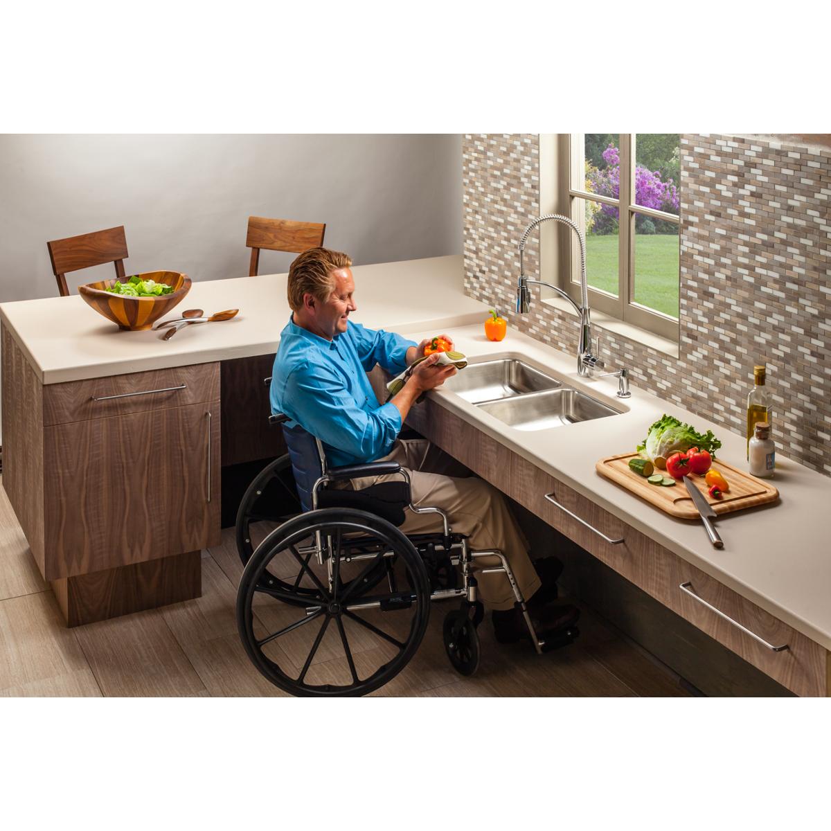 Stainless steel double bowl undermount sink installed in kitchen countertop with wheelchair-accessible clearance.