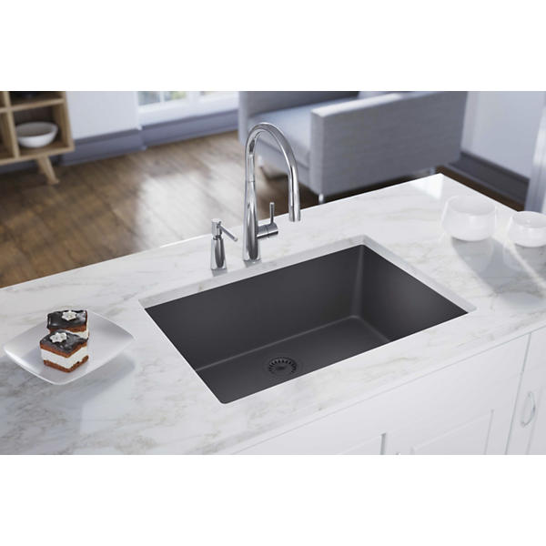 Charcoal quartz undermount sink with single rectangular bowl installed in white marble countertop.