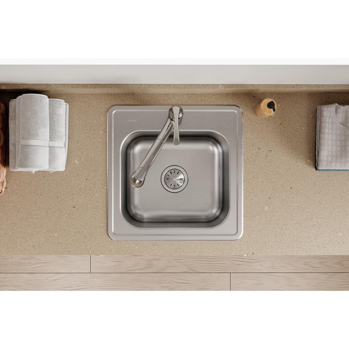 Stainless steel square drop-in laundry sink with single bowl and drain, installed in countertop with faucet.