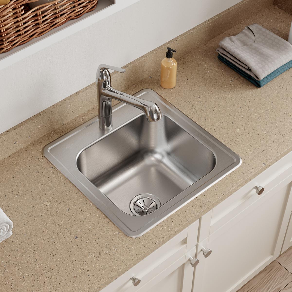 Stainless steel square drop-in sink with single bowl, faucet, and drain strainer installed in countertop.