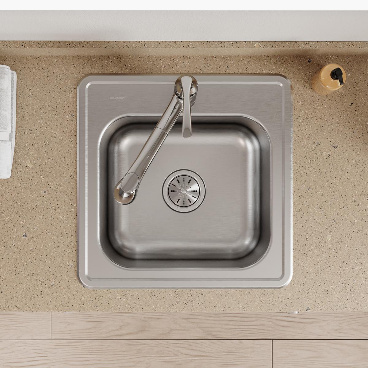 Stainless steel single bowl drop-in laundry sink with drain hole and faucet, installed in countertop.